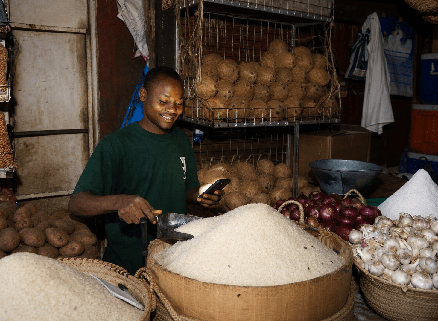 Market vendor using Business Pilot on his phone while selling grains and cereals