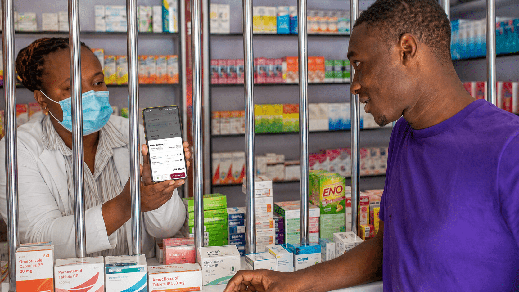 Pharmacist showing a digital order summary on Business Pilot to a customer